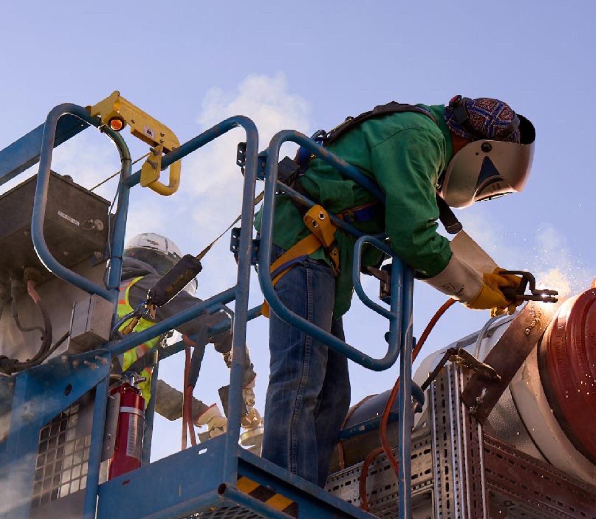 A diverse group of trainees is engaged in a hands-on workshop, practicing electrical wiring on training panels under the watchful eye of an instructor. This setting exemplifies the commitment to launching America's workforce academy and preparing the next generation of skilled trade workers for long-term careers in the United States labor market.